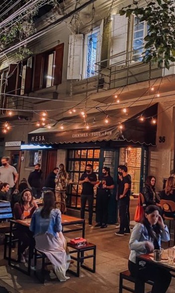 Fachada do Mesa à noite na Rua Dinarte Ribeiro, com mesas na calçada e luzes de varal